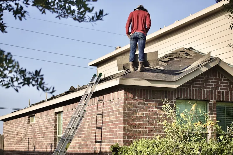 Professional roofer working on a residential roof in Highland Forest